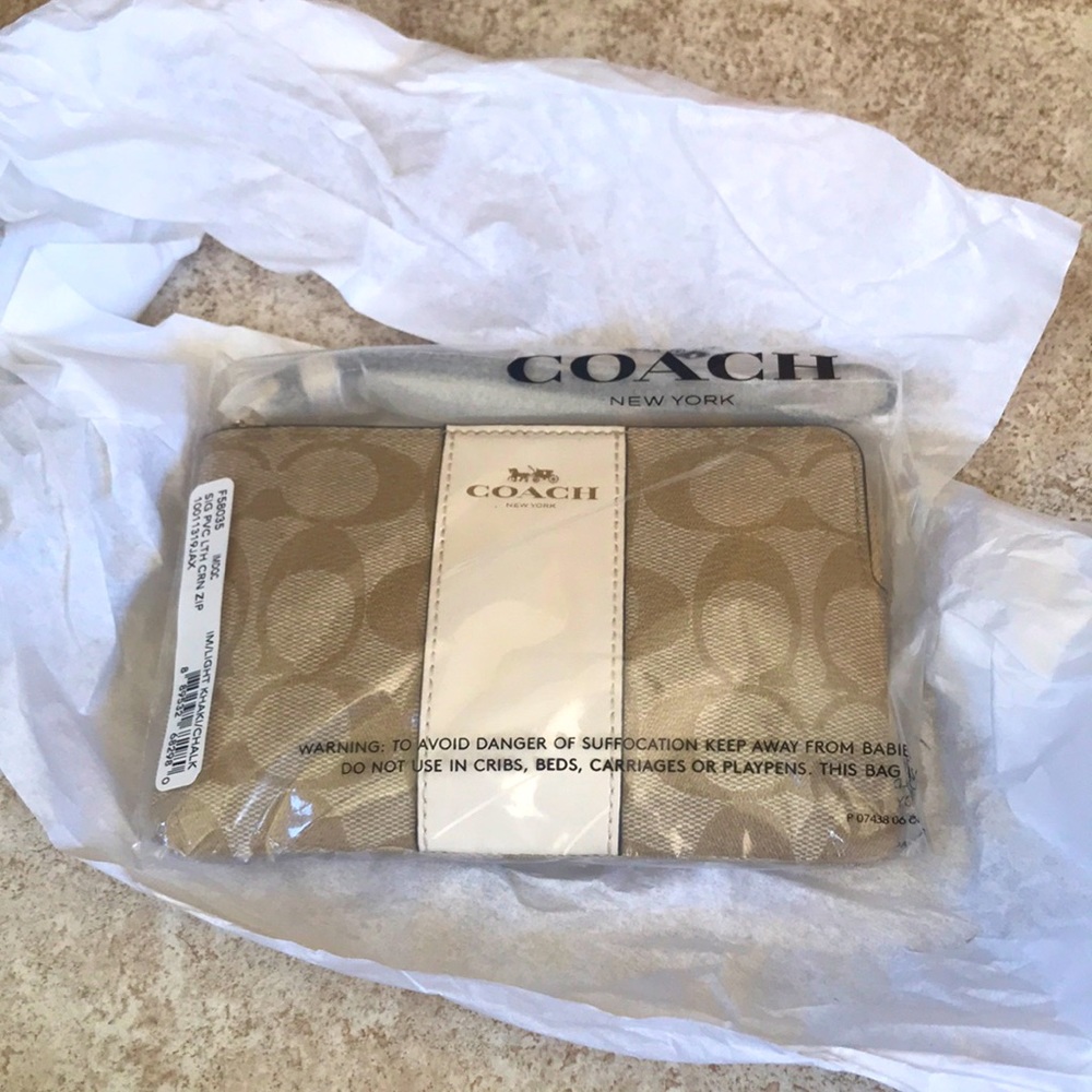Coach wristlet-canvas w/ crossgrain leather
W/Wrist strap.6 1/4" x 4" x 1/2" New